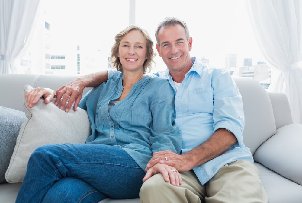 Middle-aged couple sitting together at home Middle-aged couple sitting together at home