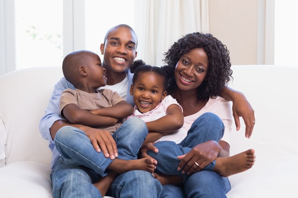 Parents relaxing at home with their two young children Parents relaxing at home with their two young children